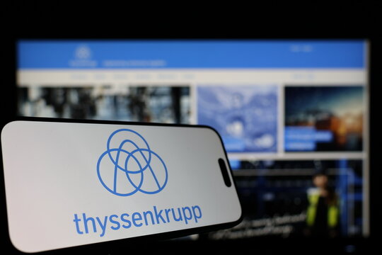 Kiel, Germany - 01-12-2026: Smartphone displaying thyssenkrupp logo in front of the company website on a monitor