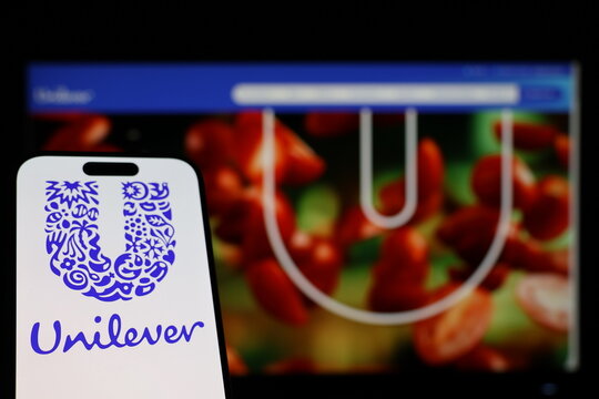 Kiel, Germany - 01-12-2026: Smartphone displaying Unilever logo in front of the company website on a monitor