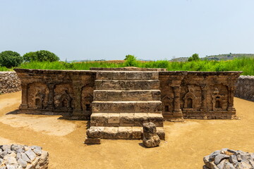 View of ancient stonework and weathered steps ascend to a platform under a vast sky, amidst the historical landscape, Taxila, Punjab, Pakistan.