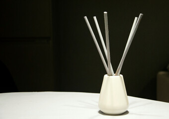 Minimalist aroma diffuser with reed sticks on table