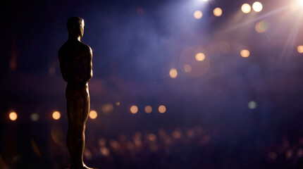 Golden trophy on gala stage. Dramatic spotlight bokeh shows trophy silhouette at academy awards night, trophy symbol of success for film industry ceremony, awards season concept, premium mood