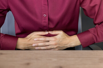 Woman feeling severe abdominal pain, indigestion, or gastritis, holding her hands over her stomach...
