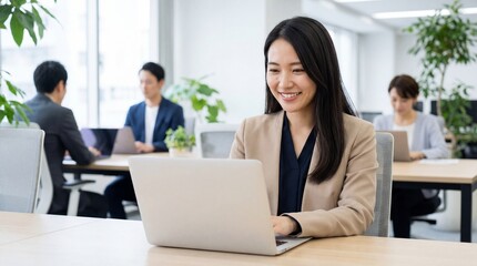 Smiling Asian Businesswoman Working on Laptop in a Modern Office Environment