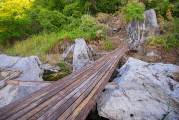 Wooden bridge over the river in the forest. Nature background.