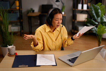 Asian woman experiencing stress during video call meeting