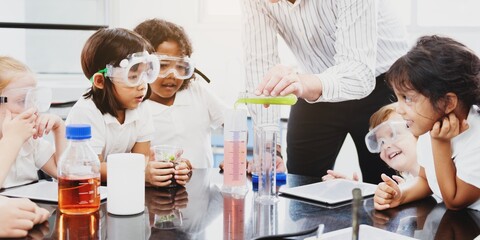 Children in a science class, wearing goggles, engaged in an experiment. Diverse group of kids learning science, exploring chemistry with enthusiasm. Elementary kids in science class.