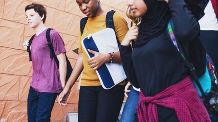 Diverse group of students walking. Students with backpacks, diverse ethnicities. Group of students walking together, diverse group, students outdoors. Diverse teenage students at school walking.