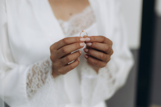 Bride holding golden engagement ring getting ready for wedding