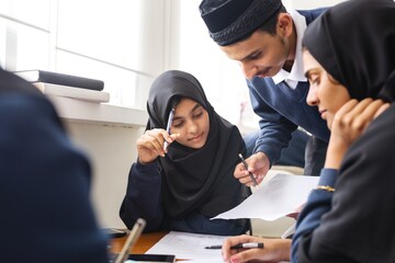 Group of Muslim students in hijabs studying together. Focused students, diverse group, engaged in learning. Collaborative study session, teamwork, education. Education and learning. Students studying