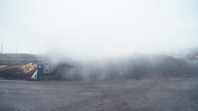 An industrial conveyor system aerator recycles organic waste using rising steam inside a waste processing plant. Depicts recycling technology and environmental engineering. This is an aerobic process
