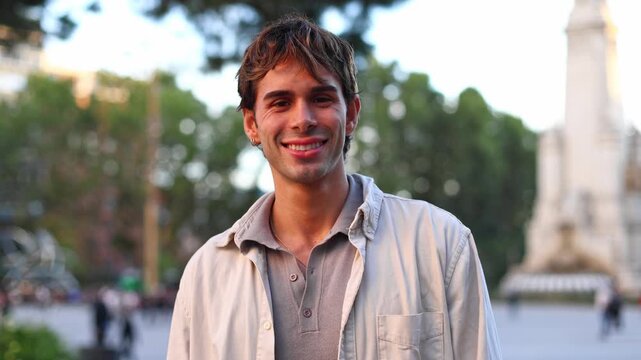 Handsome young man smiling at camera outdoors