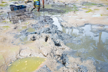 Workers are working in the mud at the construction site of a new house.