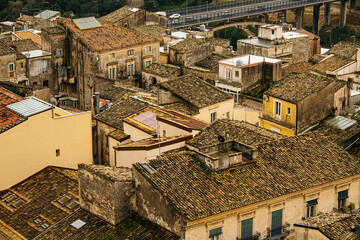 Panoramic View Over Ragusa From Cathedral Of San Giovanni Battista: Historic Sicilian City Rooftops, Church Domes, And Dense Stone Architecture Under Overcast Sky