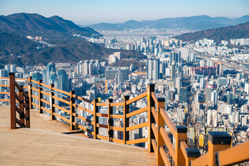 Busan cityscape viewed from a wooden observation deck with a railing