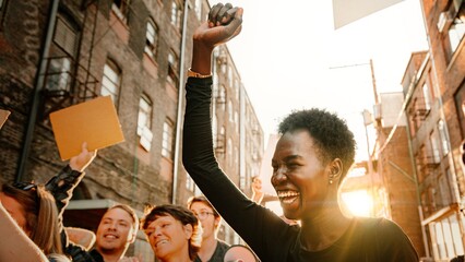 Diverse group of happy people holding protest signs. Group of various ethnicity people united in protest. Protest signs raised by people. Diverse group of happy people in protest with blank paper sign