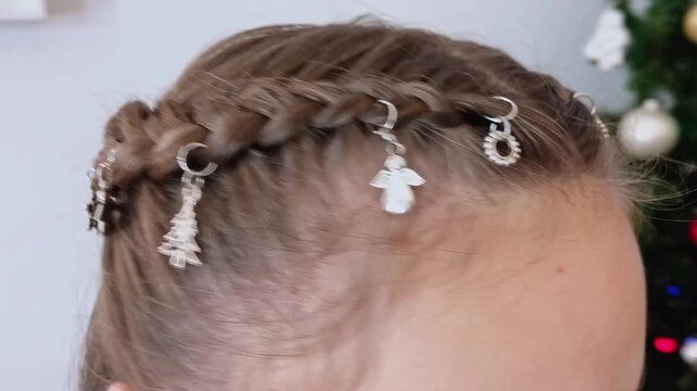 Trendy double braids hairstyle decorated with silver hair rings close-up