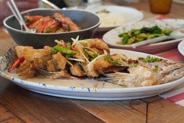 Sliced ​​fried fish with coconut milk curry and chilli in a ceramic dish on the table background, food, hot, object, delicious