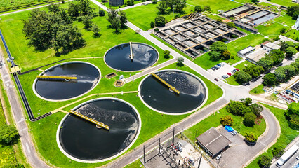 Vis&atilde;o a&eacute;rea de tanques circulares de saneamento industrial com sistema de lodo ativado, evidenciando tratamento de efluentes, controle ambiental e infraestrutura de saneamento.