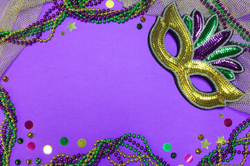 Colorful beads and a shining mask adorn a playful background with copy space, celebrating Mardi Gras
