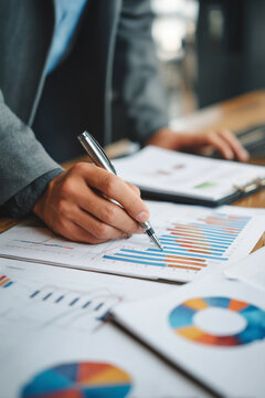 An insurance agent analyzing financial charts while preparing coverage recommendations for a corporate client.