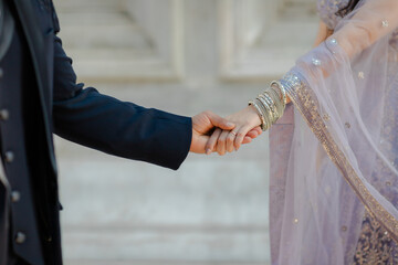 Romantic Union: Elegant Couple Hold Hands in Wedding Attire, Symbolizing Love, Commitment, and a...