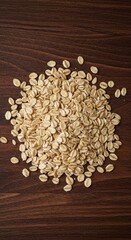 Dry, healthy rolled oat flakes, common cereal grains, scattered across a rustic wooden table, perfect ingredients for cooking breakfast porridge, morning, oatmeal, wholesome