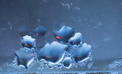 Abstract Water Droplets on Blue Glass Surface with Red Bokeh