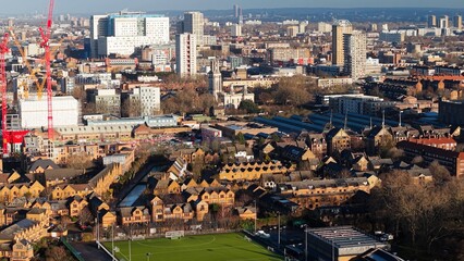 London cityscape with residential buildings, a stadium, and active construction sites