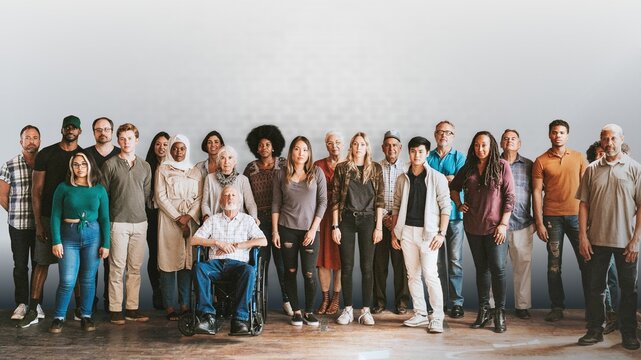 Group of diverse people standing in front of a brick wall