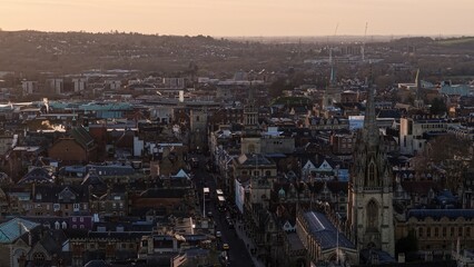 Oxford cityscape featuring Magdalen College and other university buildings under a warm sky
