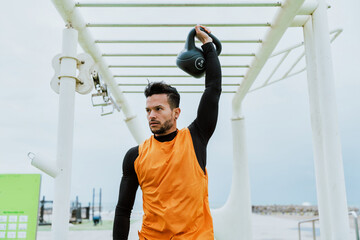Young athlete training in the morning on the beach at the gym