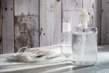 Clean hands hygiene concept showing hand sanitizer and face masks indoors