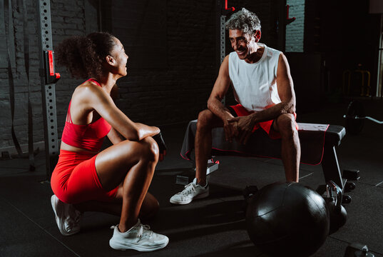 Fit senior man in the gym with his personal trainer.