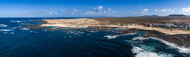 Aerial view of Fuerteventura north coast in Canary Islands shows turquoise coves, black volcanic...