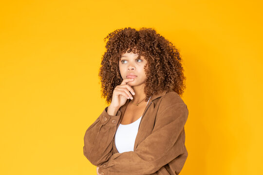young latina woman with a thoughtful expression isolated on white background