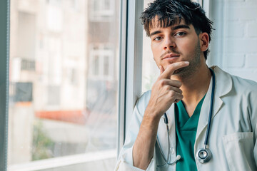 doctor with uniform and stethoscope at the window thoughtful