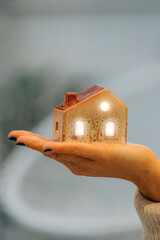 hand holding a house with light and lighting, energy
