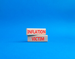 Inflation Victim symbol. Wooden blocks with words Inflation Victim. Beautiful blue background. Business and Inflation Victim concept. Copy space.