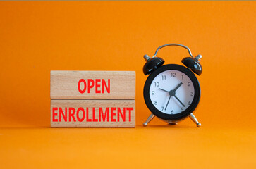 Open Enrollment symbol. Wooden blocks with words Open Enrollment. Beautiful orange background with alarm clock. Business and Open Enrollment concept. Copy space.
