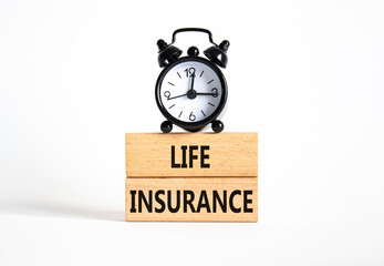Life insurance symbol. Concept word Life insurance on wooden blocks. Beautiful white background with alarm clock. Business and Life insurance concept. Copy space