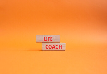 Life Coach symbol. Concept word Life Coach on wooden blocks. Beautiful orange background. Business and Life Coach concept. Copy space