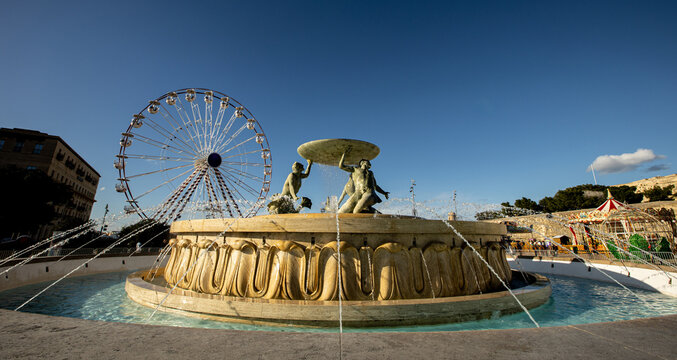 Majestic Tritons fountain by the City Gate of Valletta under a vibrant sky