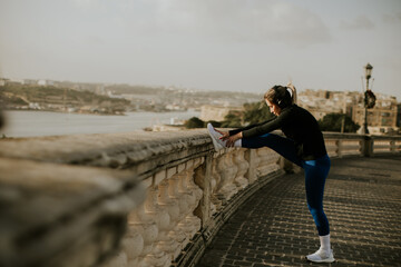 Obraz premium Woman exercises by the waterfront in Malta during a sunny day