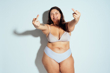 Plus size woman posing in studio in lingerie