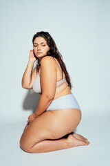 Plus size woman posing in studio in lingerie