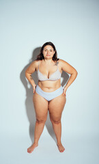 Plus size woman posing in studio in lingerie