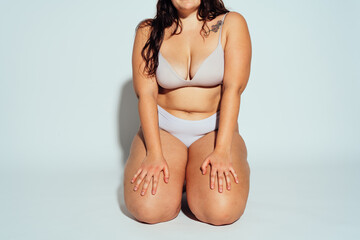 Plus size woman posing in studio in lingerie