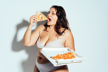 Plus size woman posing in studio in lingerie