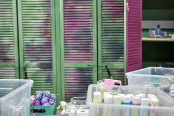 Creative workshop interior with plastic storage boxes filled with paints, fabrics, yarn, and craft materials. Colorful shelves and tools create an inspiring handmade art studio atmosphere