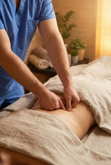 Male massage therapist performing therapy on client in spa setting  